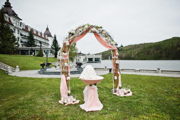 Arch with decor flowers and small table for wedding registration.