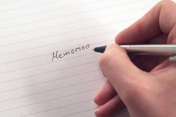 Hand writing word Memories with pen in handwriting on lined paper