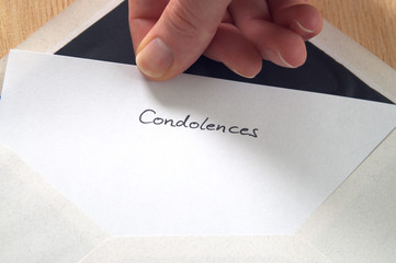 Condolences, hand pulling letter from envelope