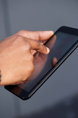 african american hand holding digital touch screen tablet
