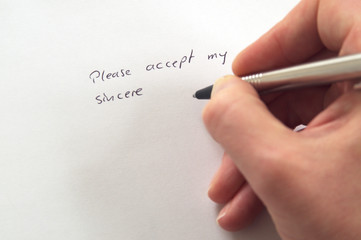 Please accept my sincere ... (apologies) in handwriting by hand with pen on white paper