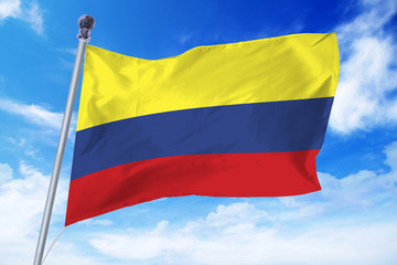 Fototapeta na wymiar Flag of Colombia developing against a clear blue sky