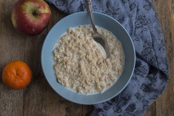 Oatmeal porridge in bowl for breakfast on rustic wooden table