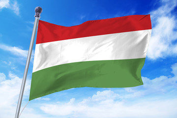 Flag of Hungary developing against a clear blue sky