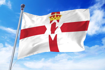 Flag of Northern Ireland developing against a clear blue sky