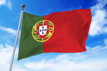 Flag of Portugal developing against a clear blue sky