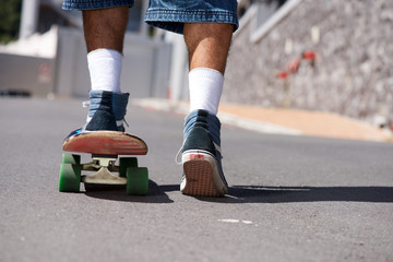 back view of young man skateboarding outside © mimagephotos