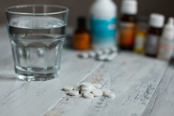 The different pills and glass of water on table. Medicine concept about health and drugs