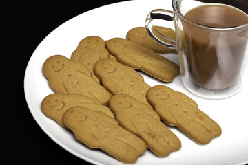 Afternoon snack comfort food. Gingerbread men biscuits and a cup of tea.