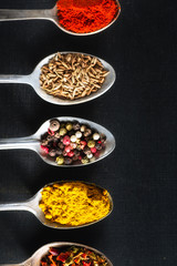 spoons with salt and spices closeup on chalkboard