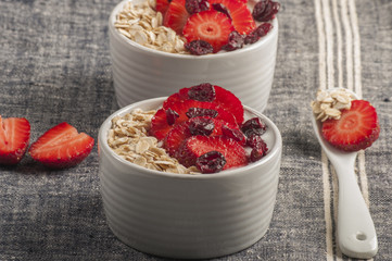 Yogurt with oat flake and fresh berries for healthy morning meal put on white wood background, Breakfast set.