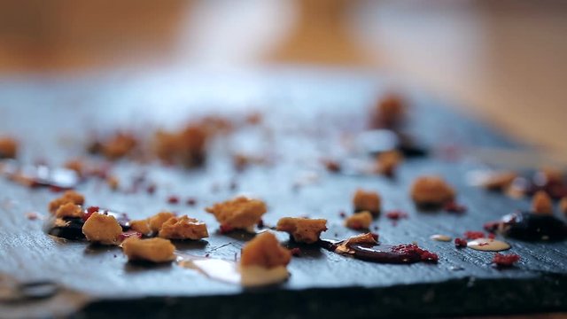 closeup refocusing shot of honey crumbs on a black plate for making a chocolate dessert. Decorated with cream. Making in a restaurant.