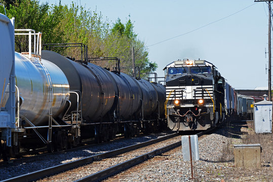 train locomotive passing additional freight train on parallel tracks