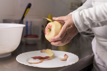 cook peeling apples in the kitchen