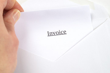 Invoice printed on white paper and envelope, hand opening it, white background