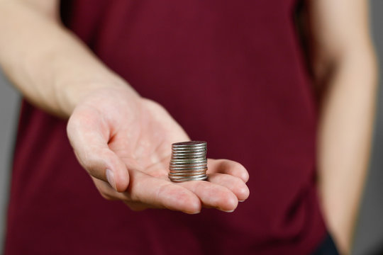 Man Holding Coins In His Hand. Reaches Out To The Camera. Closeup. Isolated