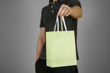 The guy is holding a gift package. Closeup. Isolated
