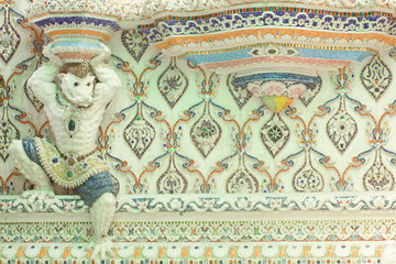 Fototapeta na wymiar Sculpture of half human and wild boar monsters, demons, decorated with mosaic or stucco on the church wall at Wat Pariwat Temple, Bangkok, Thailand