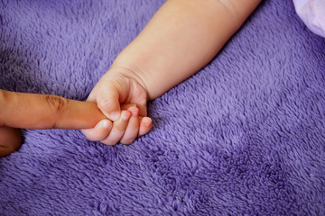 Hand baby holding hand of mother's closeup. concept love of family.