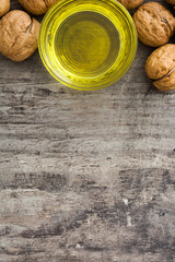 Walnuts oil on wooden background
