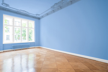 empty room in new apartment - blue walls and wooden floor
