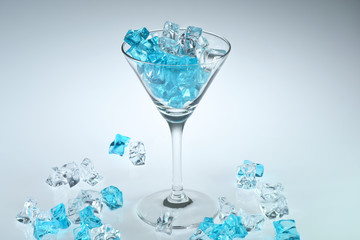Glass of martini with cube ice on white background