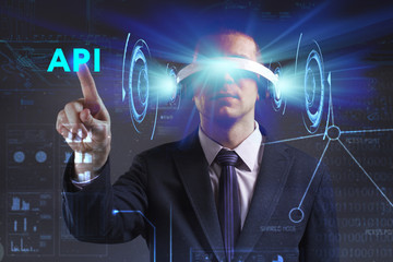 Business, Technology, Internet and network concept. Young businessman working in virtual reality glasses sees the inscription: API