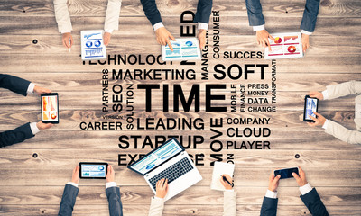 Top view of businesspeople sitting at table and using gadgets