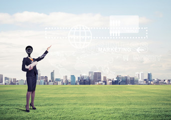 Camera headed woman standing on green grass against modern citys