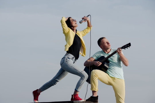 music band of man and woman with guitar and microphone
