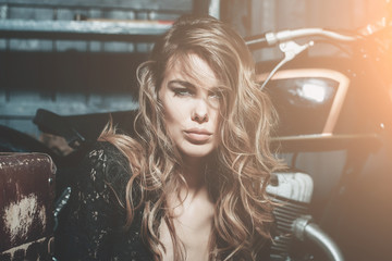 Plakat fashion model sitting at metallized motorcycle