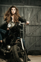 Naklejka na ściany i meble biker in leather jacket sitting on vintage motorcycle
