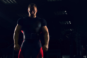 Handsome athlete is standing with a sports belt