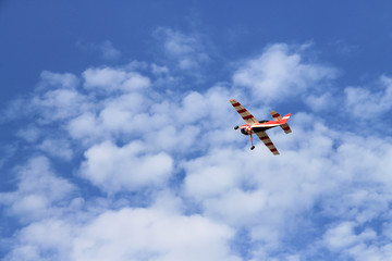 Fototapeta na wymiar Model of a red airplane in a blue sky. Aeromodelling.