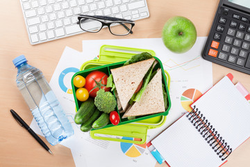 Office desk with supplies and lunch box