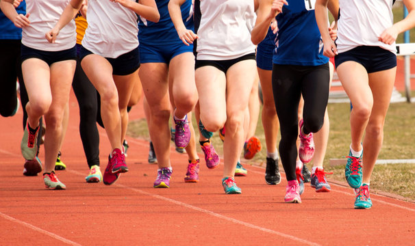 Girls racing on a track in a large group
