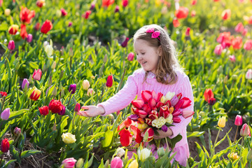 Little girl in tulip flower garden