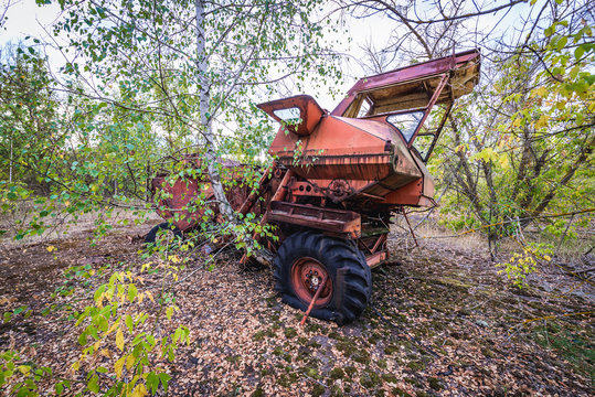 Abandoned combine vehicle in collective farm near Zymovyshche ghost village in Chernobyl Exclusion Zone, Ukraine