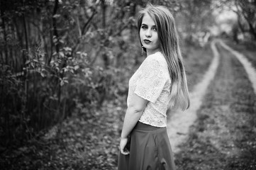 Portrait of beautiful girl with red lips at spring blossom garden, wear on red dress and white blouse.