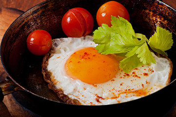 Toasted egg in a frying pan, sprinkled with hot pepper.
