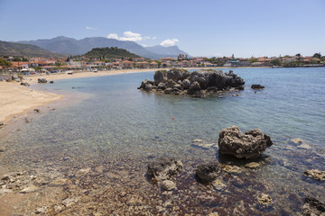 Fototapeta na wymiar beautiful beach of Stoupa in greece on sunny day in spring on peloponnese with flowers and sunbeds