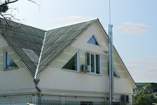 The roof is of asbestos roof slate. Old slates roof with chimney and lightning conductor. Onduline Roofing Sheets.