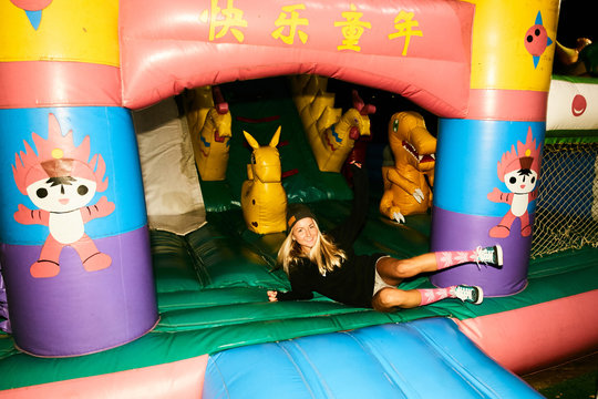 Girls fooling around in an inflatable trampoline like children