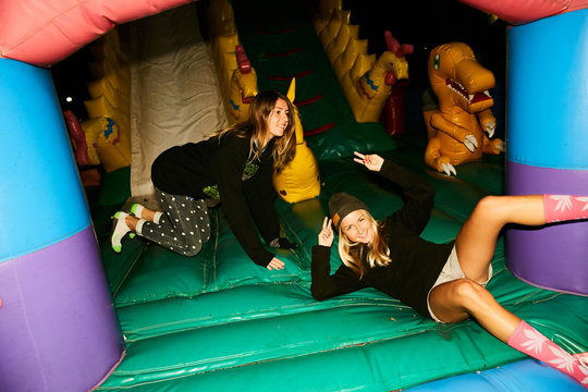 Girls fooling around in an inflatable trampoline like children