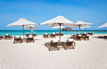 beach chairs under umbrella at ocean front