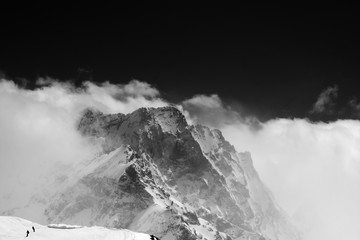 Black and white view on snow mountains in clouds