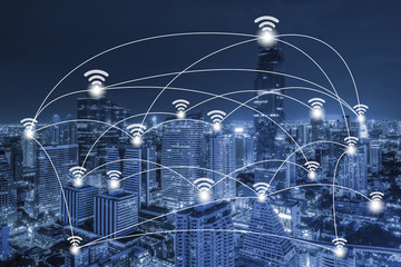 Wifi network connection concept on blue tone aerial view of cityscape business district at twilight background.