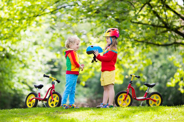 Kids ride balance bike in park