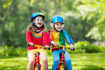 Kids ride balance bike in park