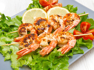 plate of grilled prawns with salad and cherry tomatoes